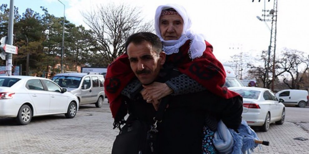 Vefalı evlat 17 yıldır annesini sırtında taşıyor